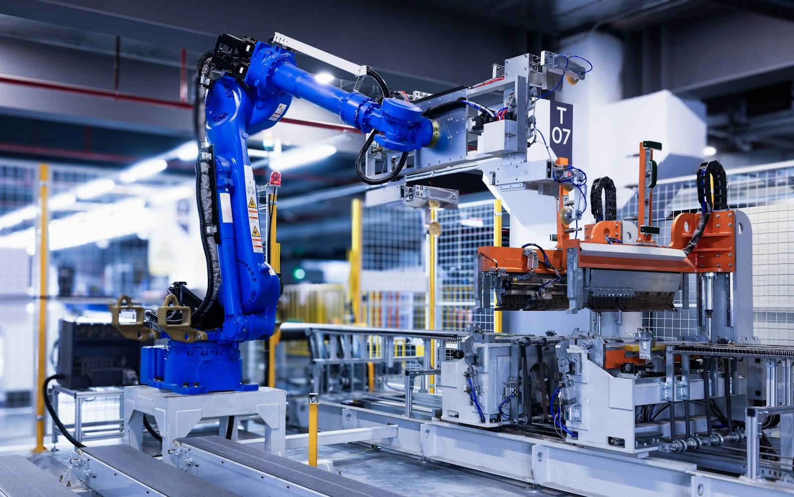 Blue industrial robot arm operating on an automated factory line