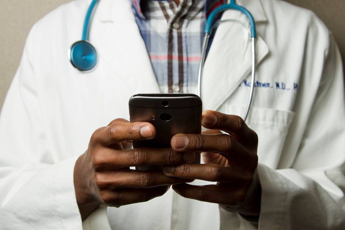 Doctor with a stethoscope using a mobile device